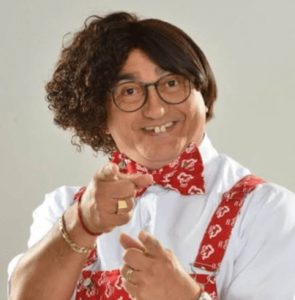 Personagem de peruca e óculos apontando o dedo