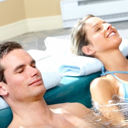 Casal deitado relaxando numa banheira de spa